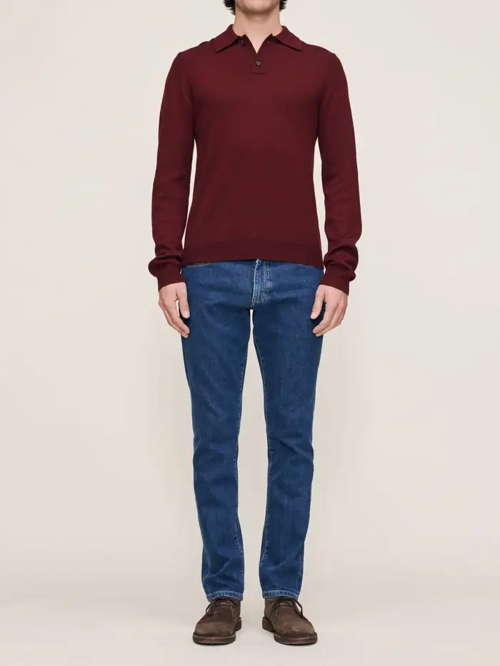 Model wearing a maroon polo shirt and blue jeans