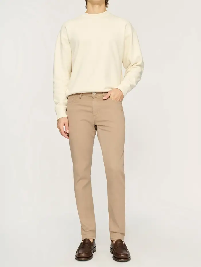 Model wearing a cream sweater and khaki pants
